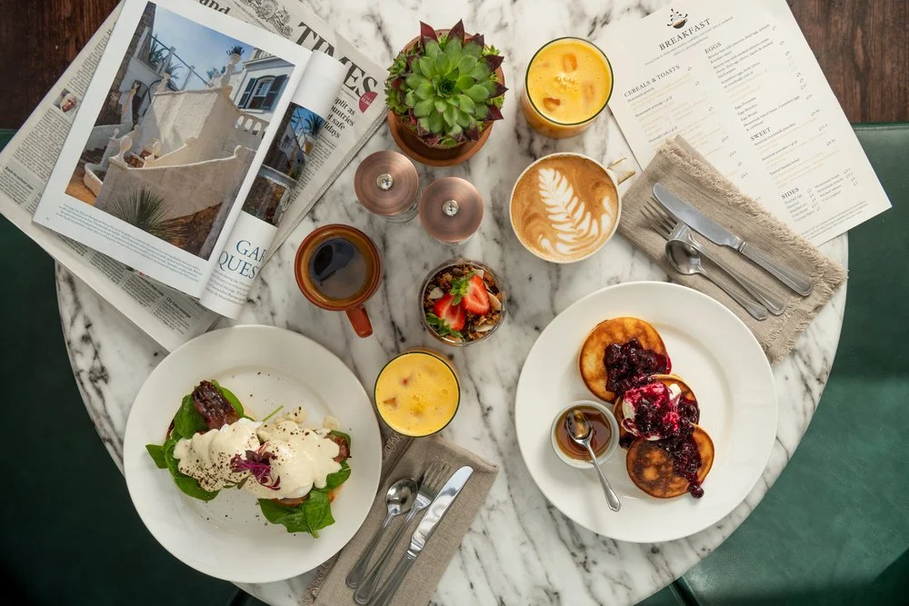 Breakfast dishes, tea and newspapers on a table at Orange Pekoe