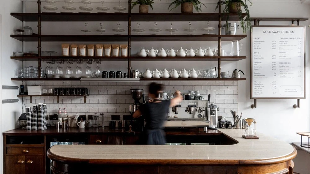 The counter, tea shelves and seating inside Orange Pekoe in Barnes